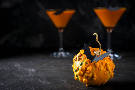 有趣的南瓜,黑色蝙蝠和橙色鸡尾酒在万圣节的玻璃无缝图案有趣的仙人