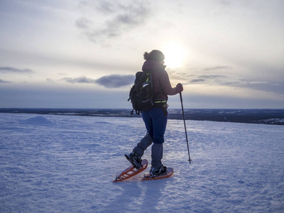 穿雪鞋的女人在冬天的山上徒步旅行复制空间