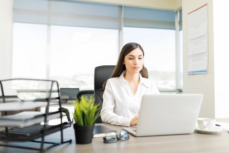 s information on laptop at desk in 