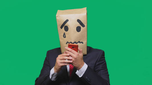 情感的概念, 手势。一个人在他的头上有一个包裹, 用一个画笑脸哭, 伤心, 在电话上交谈