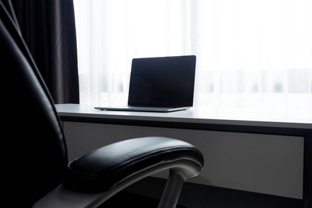 办公桌工作场所，白色桌子上有笔记本电脑，家庭办公室