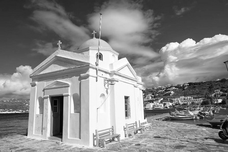 在希腊米科诺斯岛的阿基欧斯尼可拉斯教堂。海码头上有蓝色圆顶的寺庙建筑。在阳光明媚的海滨教堂。在地中海岛上的暑假。流浪和旅行概念