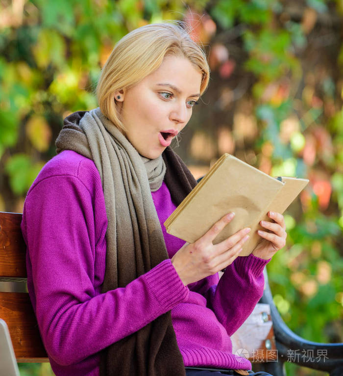 智力爱好.女孩坐板凳放松与书秋季自然背景.书女士在户外看书读书.