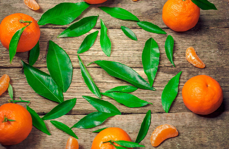 成熟多汁的橘子柑桔，叶子放在木板上，直接从树上脱落