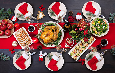 烤火鸡。 圣诞晚餐。 圣诞节的桌子上摆着一只火鸡，上面装饰着明亮的金箔和蜡烛。 炸鸡桌。 家庭晚餐。 顶部视图