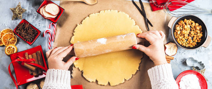 圣诞食品概念。 女人正在做姜饼男人饼干在圣诞节关门。
