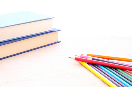 回到学校极简主义背景彩色铅笔和书本孤立在白色桌子上
