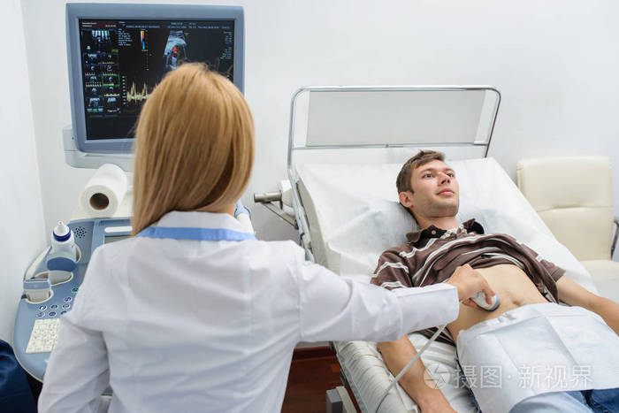 女医生用超声波检查腹部一男子