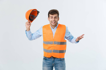 失望英俊的工程师穿着橙色背心和牛仔裤与头盔, 查出的白色背景