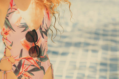 快乐的年轻女子穿着泳衣，在豪华度假村的游泳池玩得很开心。 暑期旅游度假理念。