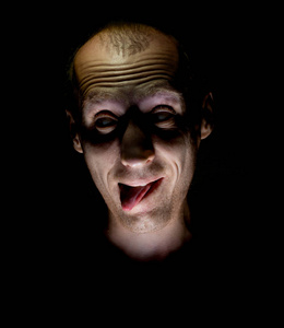 时尚的黑暗幽默的成年白种人的肖像,他笑得像疯子,伸出舌头.照片