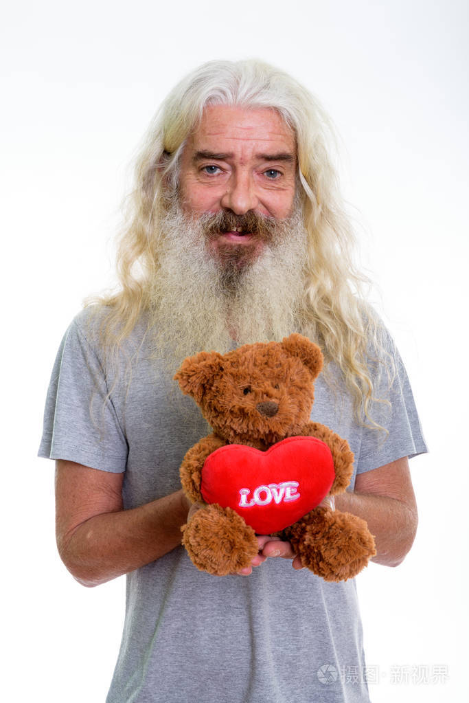 工作室拍摄的愉快的高级胡子男子微笑, 而持有 te