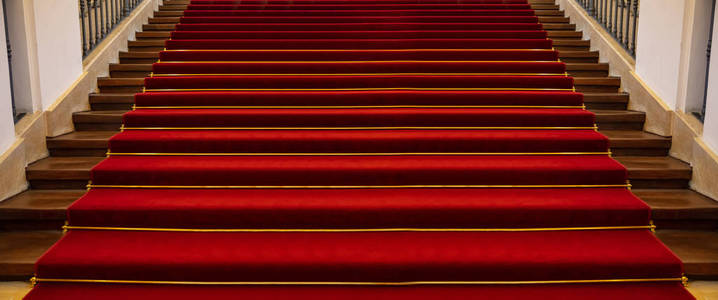 红地毯豪华。 铺有红地毯背景透视图的木制楼梯
