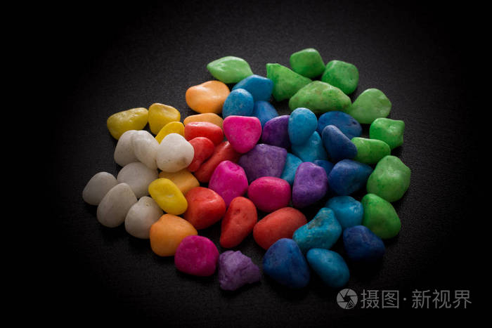 黑色背景上一堆五颜六色的小石子