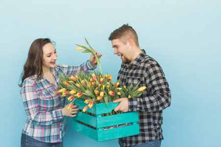 快乐的花店固定在蓝色背景的大木箱里的郁金香