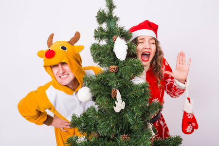 笑话, 圣诞节和假期概念在圣衣男子的幸福的女人在鹿的服装是微笑和有乐趣
