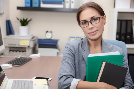 一位漂亮的上班族的肖像,漂亮的女性,手里拿着文件夹,在工作场所,成功