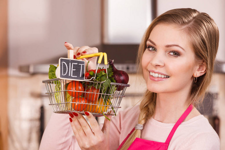 厨师快乐的女人拿着购物篮和饮食标志和许多五颜六色的蔬菜。 健康饮食生活方式素食。