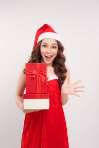 戴着圣诞帽的可爱女孩的肖像，白色背景上有礼物盒