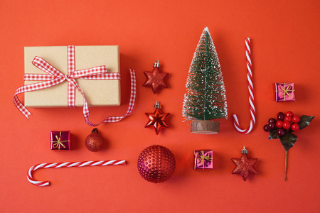 圣诞节背景与礼品盒装饰和装饰品在红色桌子上。 顶部视图从上面。 平躺着