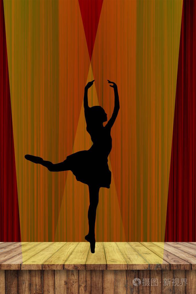 一位年轻的芭蕾舞女演员在舞台上以红色的幕布背景,以尖角的姿态在