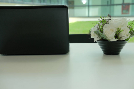  white flower in flowerpot on  workplace desk. business wo