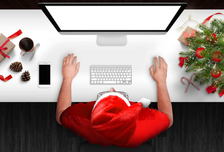 网上买圣诞礼物的家伙。 用于模拟的隔离显示屏幕。 圣诞树礼物和智能手机旁边。