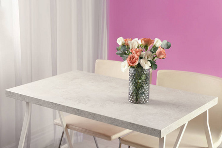 花瓶与美丽的花朵作为室内设计的元素在桌子上的房间。 文本空间