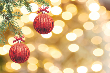 圣诞树的枝条在金色的背景上用红色的球装饰