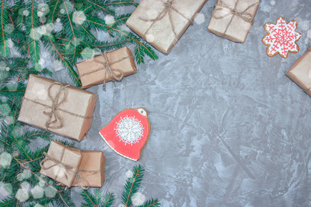 贺卡与装饰姜饼云杉枝和礼品盒在灰色水泥背景。 圣诞节新年背景的开销。 从上面看。 复制空间。