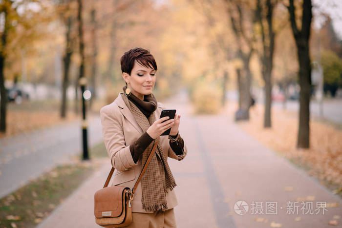 在街道上使用电话的年轻妇女的肖像