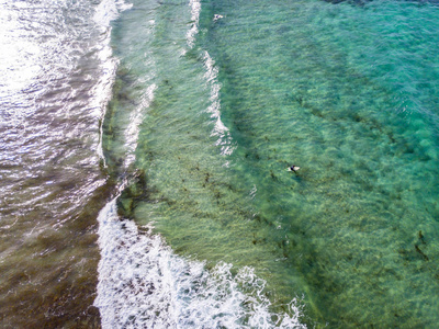 有波浪和冲浪者的清澈大海的空中景色。普拉亚德拉坎特里亚。大西洋，日落时海浪拍打在海滩上，背光。奥佐拉，兰萨罗特，加那利群岛。西