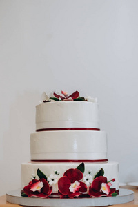装饰着红白兰花瓣的结婚蛋糕图片