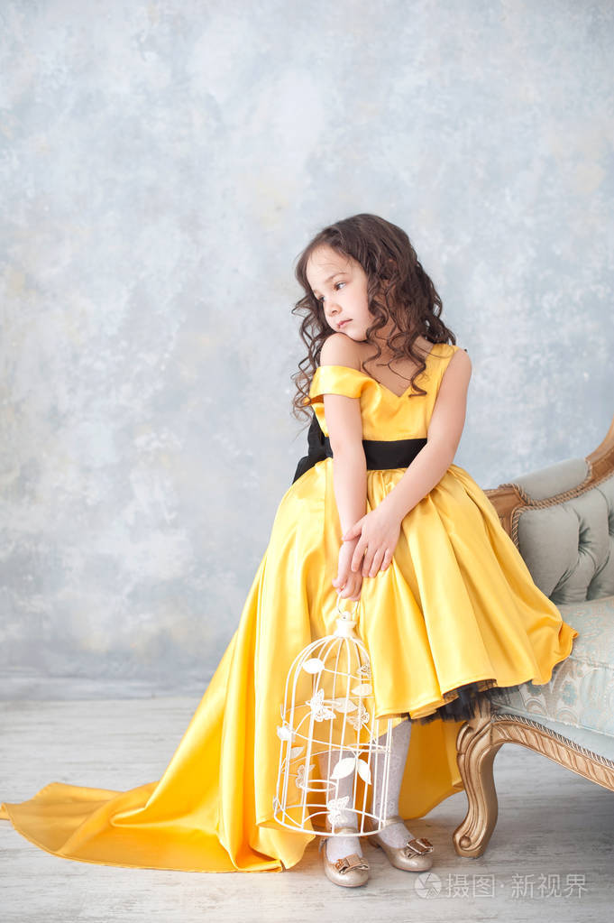 微笑的小女孩穿着公主金色连衣裙和蝴蝶的肖像