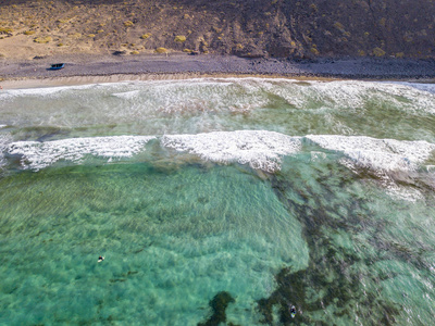 非洲景色高清图有波浪和冲浪者的清澈大海的空中景色.