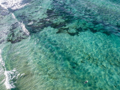 具有波浪和冲浪者的晶莹剔透的大海的鸟瞰图。 德拉坎特里亚。 大西洋海浪在日落背光时撞击海滩。 奥佐拉兰扎罗特加那利岛。 西班牙