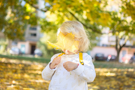 小女孩脸上挂着一片黄色的秋日