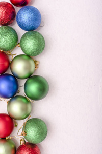 美丽的圣诞玩具绿色, 蓝色和红色在白色背景上的照片的左侧