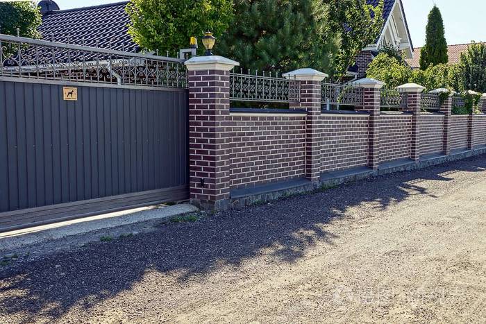 道路前面有灰色铁门和砖围栏