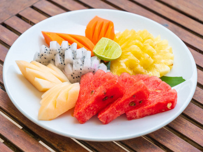 木制桌子上有许多白色盘子里的水果,健康的食品风格照片