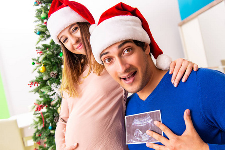 怀孕的妻子 celevrating 圣诞节与丈夫