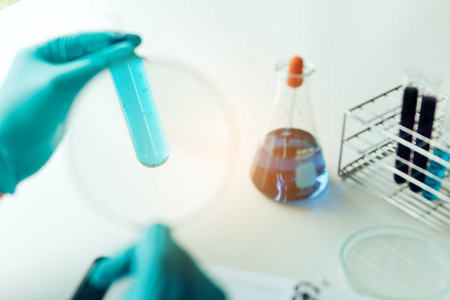 化学家或科学家使用放大镜将溶液放入玻璃瓶中。