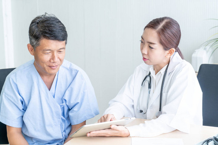 亚洲资深病人在办公室与医生协商时选择焦点