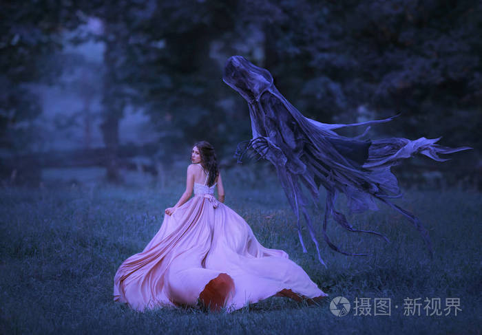 美丽的女孩穿着一件粉红色的长裙,以一个从地狱出来的黑暗恶魔的形式