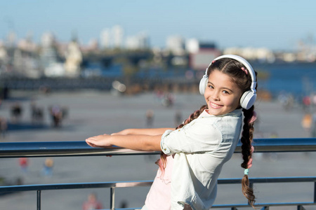 不要停止音乐。快乐的女孩戴上耳机。小音乐迷。小孩子在户外听音乐。快乐的小孩子。因为街道在歌唱