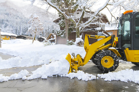 在村里的道路上清除雪的雪装载机