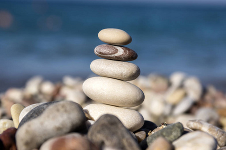 石头和鹅卵石堆在一起，和谐和平衡，一个石头凯恩在海岸