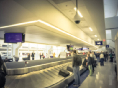 运动模糊了在达拉斯沃思堡国际机场行李提取区等待行李的不同乘客群体。 传送带上的离焦背景各种手提箱