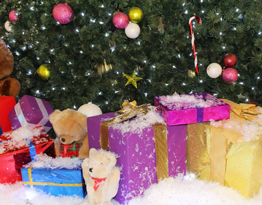 圣诞树下五颜六色的礼品盒覆盖着白雪