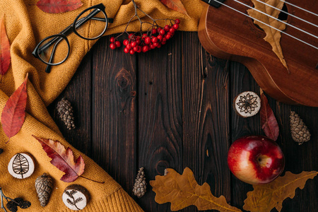 时尚的平躺观秋叶和纹理围巾在木制背景与杯子。 秋天或冬天的概念。 文本地点